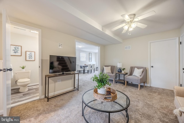 carpeted living area featuring ceiling fan and visible vents