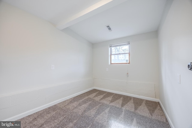 carpeted spare room with visible vents, beamed ceiling, and baseboards