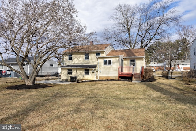 rear view of house with cooling unit, fence, a yard, a wooden deck, and a chimney