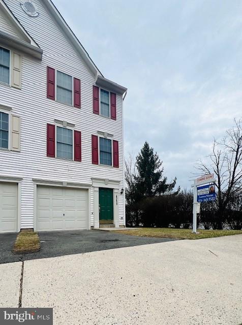 view of property featuring driveway and a garage