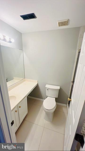 bathroom featuring toilet, vanity, tile patterned flooring, and visible vents