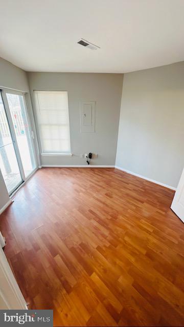 spare room with light wood-style flooring, visible vents, and baseboards