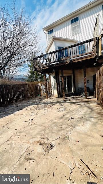 rear view of property featuring fence and a deck