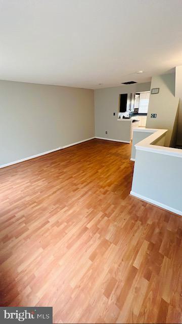 unfurnished living room with light wood finished floors and baseboards