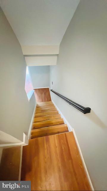 stairway featuring baseboards and wood finished floors