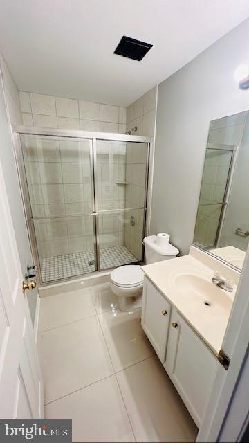 full bath with toilet, a stall shower, tile patterned flooring, and vanity