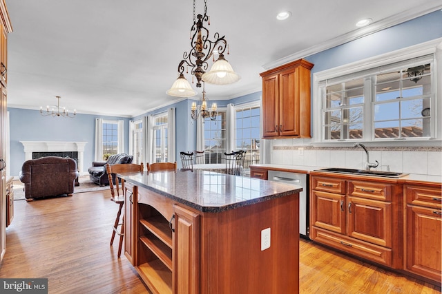 kitchen featuring an inviting chandelier, a high end fireplace, a sink, dishwasher, and crown molding