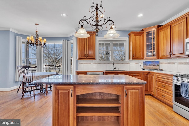 kitchen with a sink, backsplash, appliances with stainless steel finishes, and open shelves