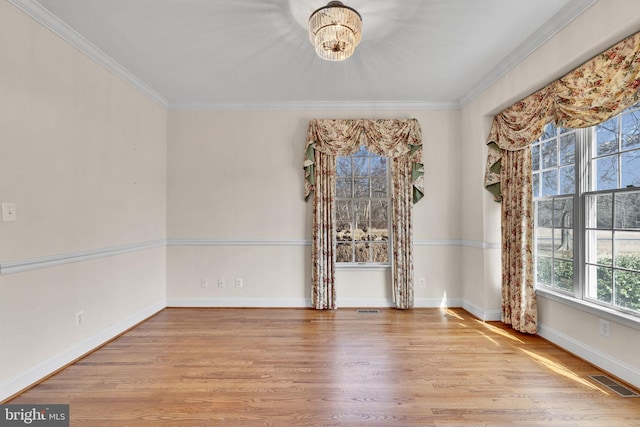 unfurnished room featuring visible vents, wood finished floors, and ornamental molding