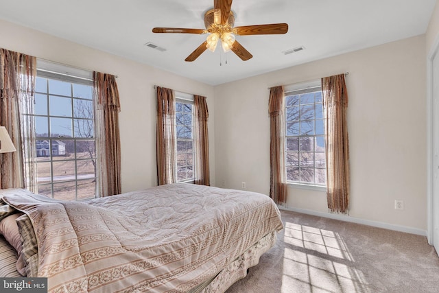 carpeted bedroom featuring visible vents, ceiling fan, and baseboards