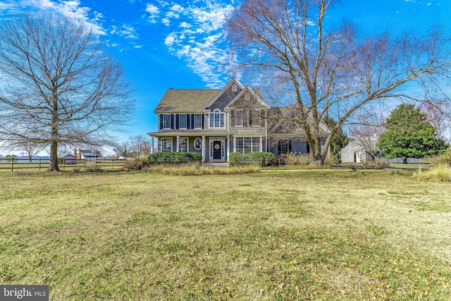 view of front facade with a front lawn and fence