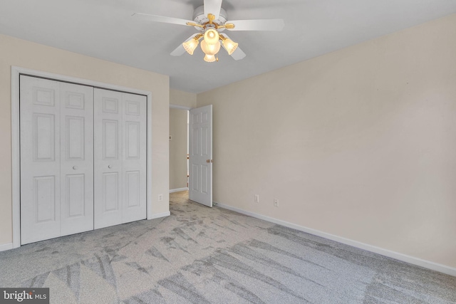 unfurnished bedroom with a closet, baseboards, a ceiling fan, and carpet flooring