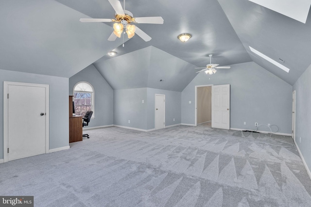 bonus room featuring vaulted ceiling with skylight, carpet flooring, a ceiling fan, and baseboards