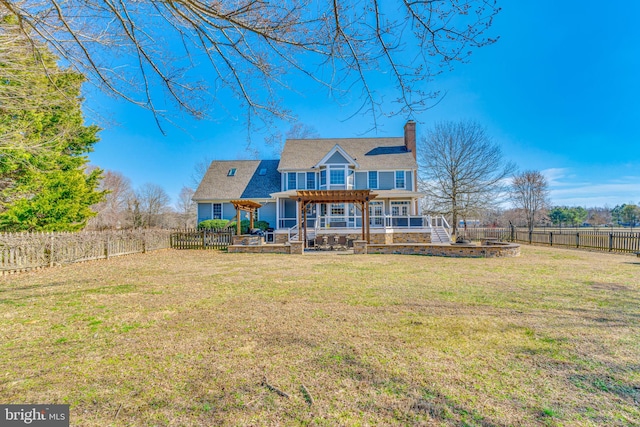 rear view of house featuring a yard, a chimney, a pergola, and a fenced backyard