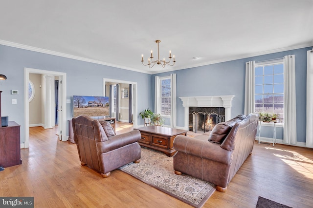 living area featuring baseboards, crown molding, light wood-style floors, and a premium fireplace