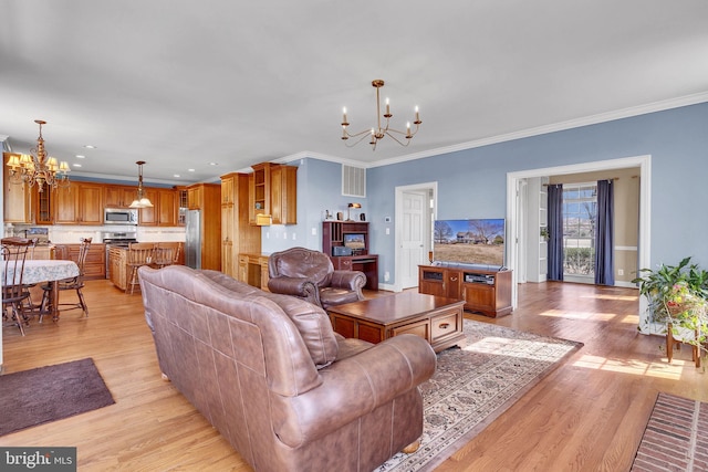 living area with crown molding, a notable chandelier, and light wood-type flooring