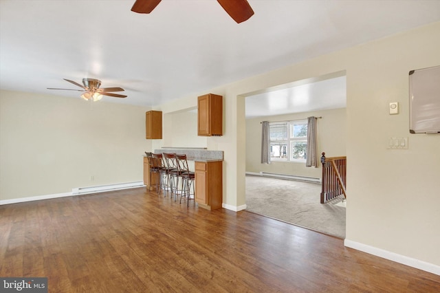 unfurnished living room with baseboards, dark wood finished floors, and baseboard heating