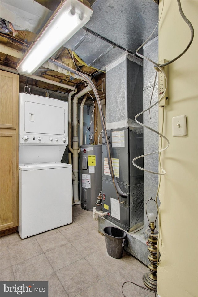 interior space with water heater and stacked washing maching and dryer