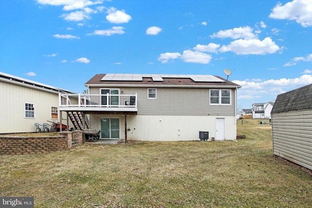 rear view of house featuring central AC, stairs, a yard, a wooden deck, and roof mounted solar panels