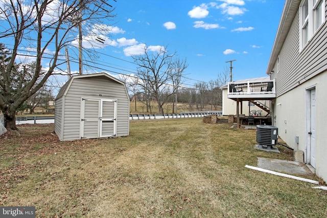 view of yard featuring an outbuilding, stairs, a wooden deck, central air condition unit, and a shed