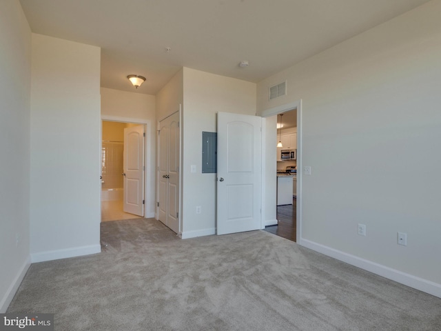 unfurnished bedroom with baseboards, electric panel, visible vents, and carpet flooring