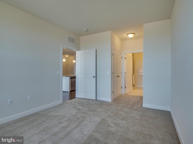 unfurnished bedroom featuring baseboards, visible vents, and carpet flooring