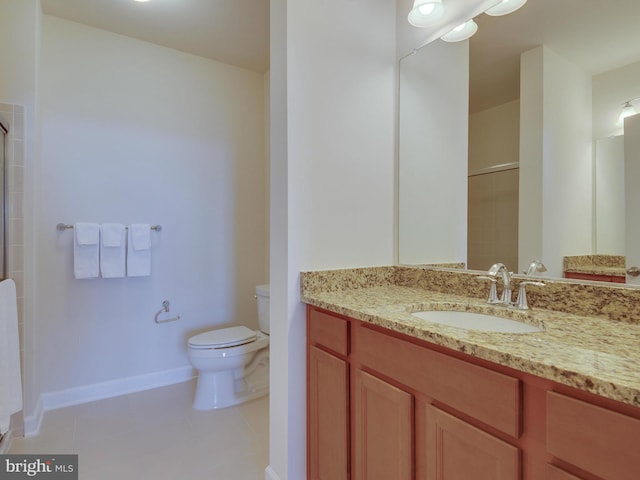 bathroom with tile patterned flooring, baseboards, vanity, and toilet