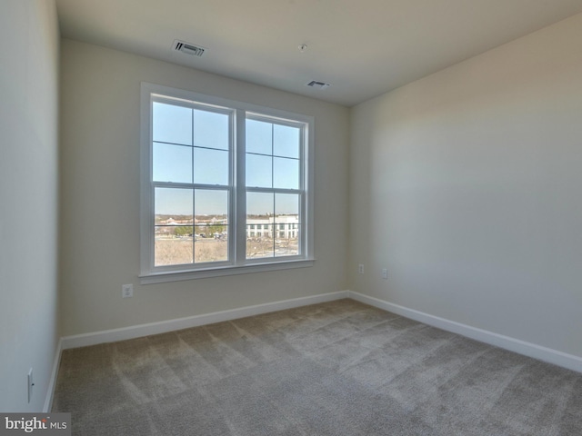 carpeted spare room with baseboards and visible vents