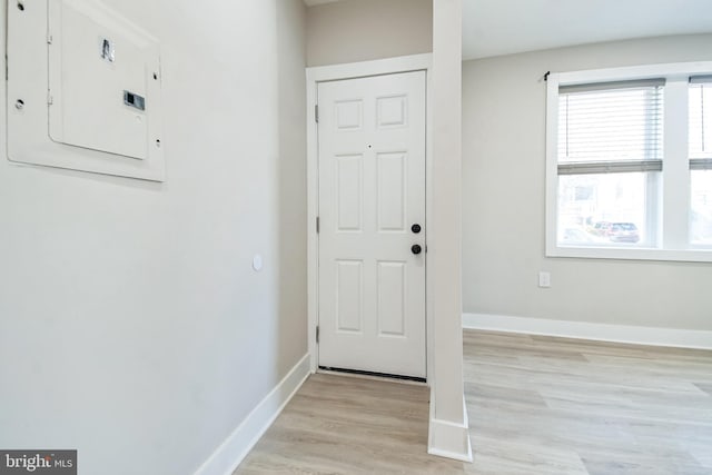 entrance foyer with light wood-style floors, electric panel, and baseboards