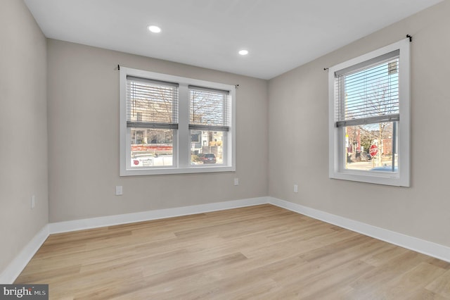 unfurnished room featuring light wood finished floors, recessed lighting, and baseboards