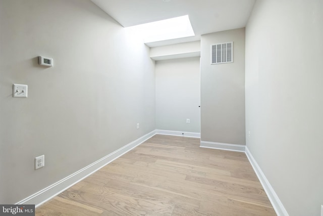 interior space featuring visible vents, light wood finished floors, and baseboards