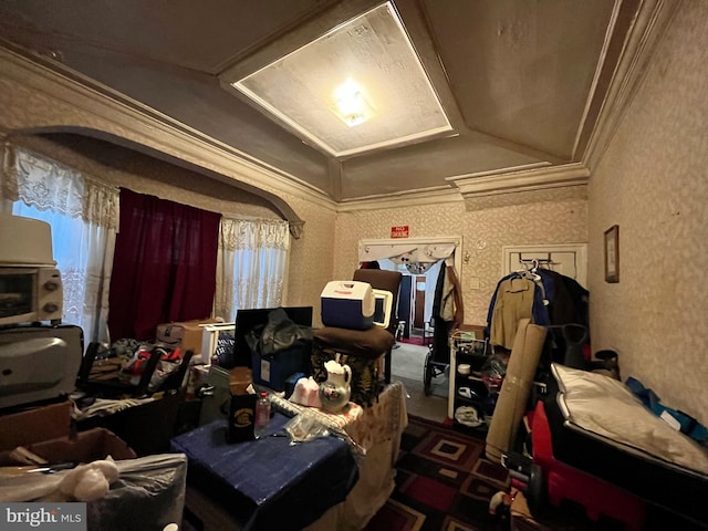 interior space featuring vaulted ceiling, ornamental molding, and wallpapered walls