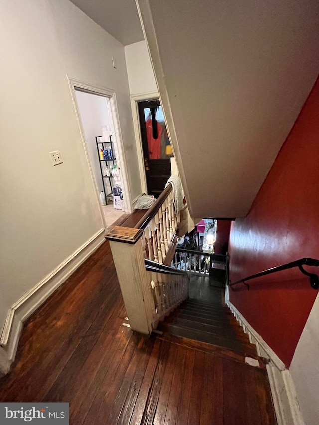 staircase with hardwood / wood-style flooring and baseboards