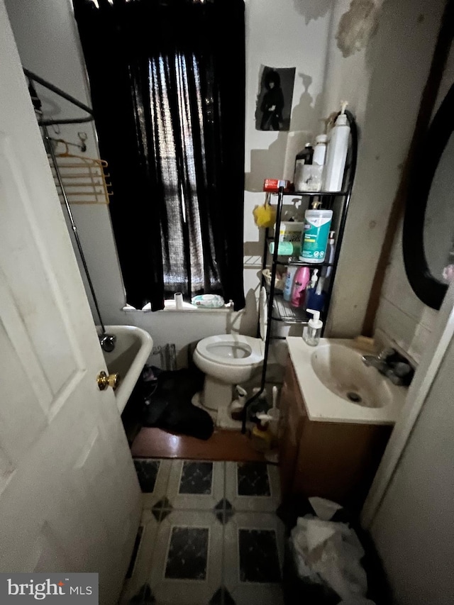 full bath featuring a tub, vanity, and toilet