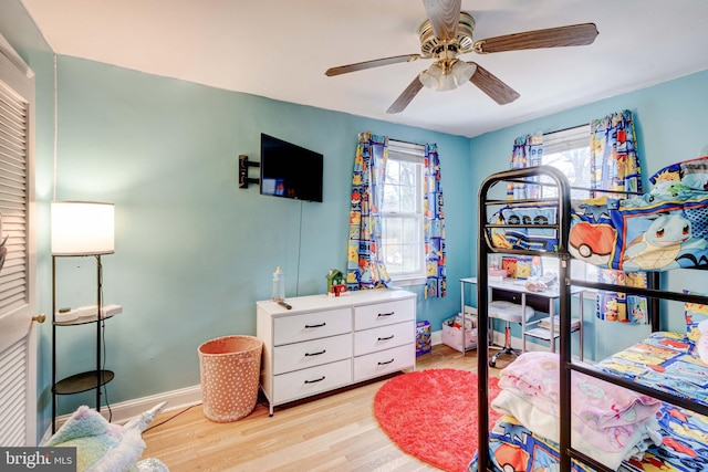 bedroom with ceiling fan, light wood-style flooring, and baseboards