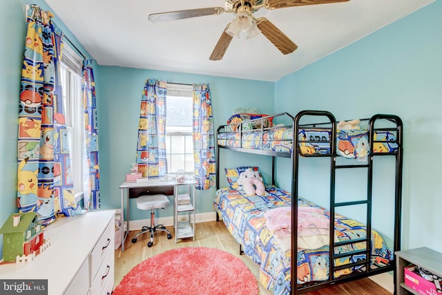 bedroom with ceiling fan, wood finished floors, and baseboards