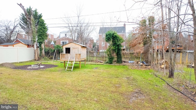 view of yard with a fenced backyard, a storage unit, and an outdoor structure