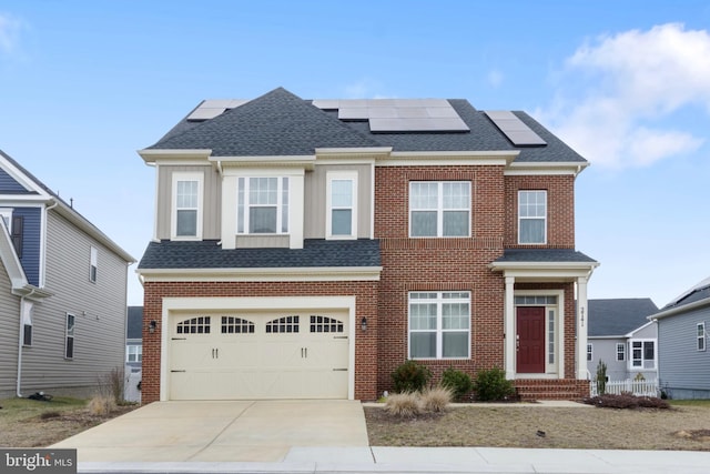 view of front of property featuring concrete driveway, roof with shingles, brick siding, and solar panels