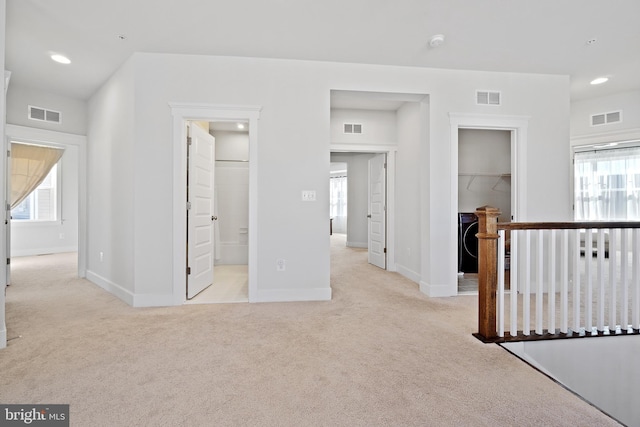 interior space featuring a wealth of natural light, visible vents, and light carpet