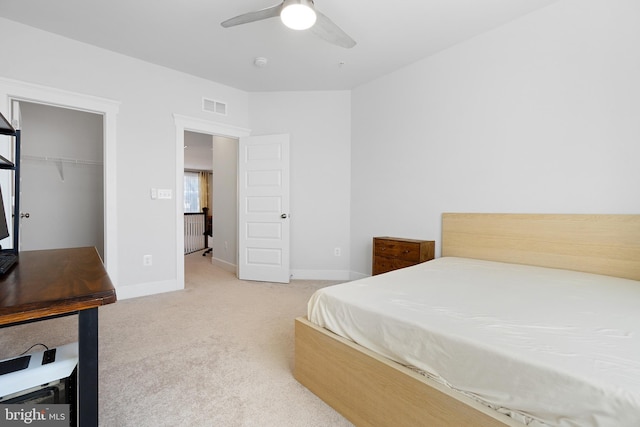 bedroom featuring a ceiling fan, light colored carpet, visible vents, and baseboards