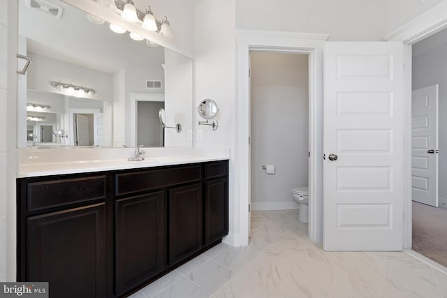 bathroom with toilet, marble finish floor, visible vents, and vanity