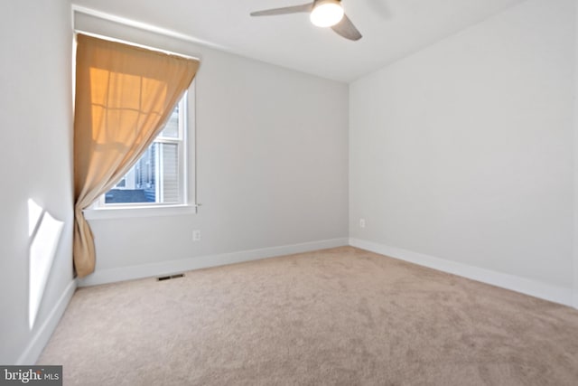 empty room with baseboards, visible vents, ceiling fan, and carpet flooring