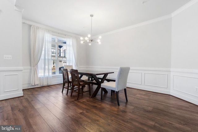 dining space with a chandelier, a wainscoted wall, crown molding, and dark wood finished floors