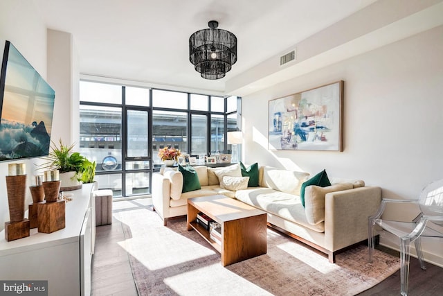 living room with expansive windows, visible vents, and wood finished floors