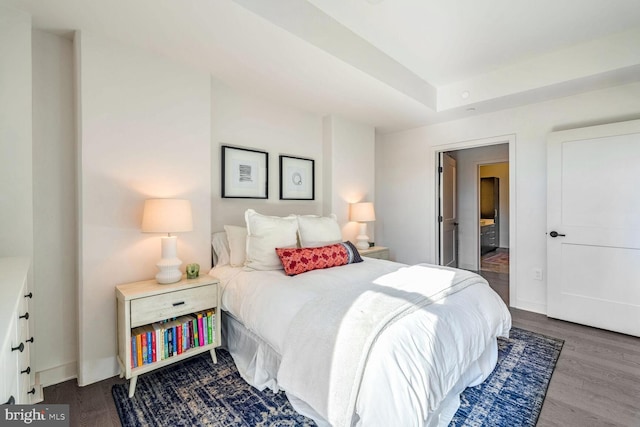 bedroom with dark wood-type flooring and baseboards