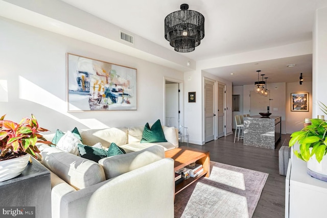 living area featuring dark wood-style floors, baseboards, and visible vents