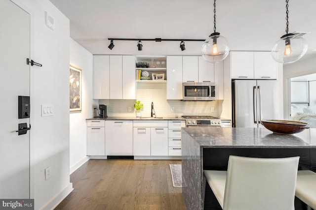 kitchen featuring white cabinets, modern cabinets, appliances with stainless steel finishes, wood finished floors, and a sink