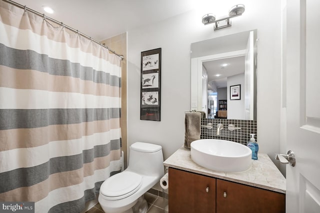 bathroom featuring toilet, curtained shower, decorative backsplash, and vanity