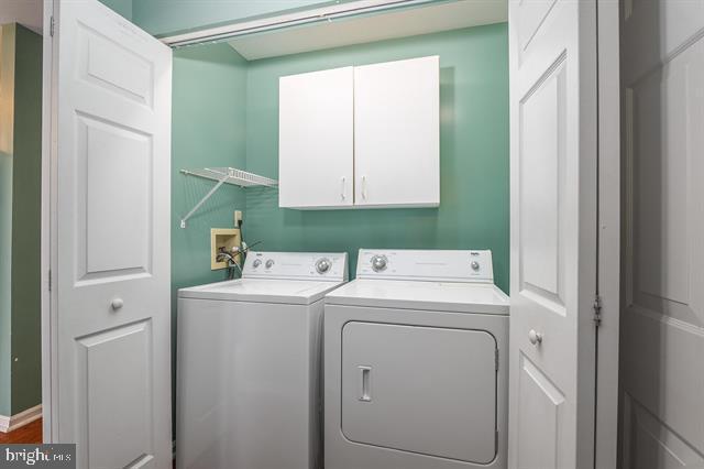 clothes washing area with cabinet space and washing machine and clothes dryer