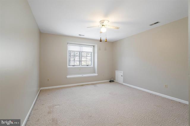 empty room featuring visible vents, baseboards, ceiling fan, and light colored carpet